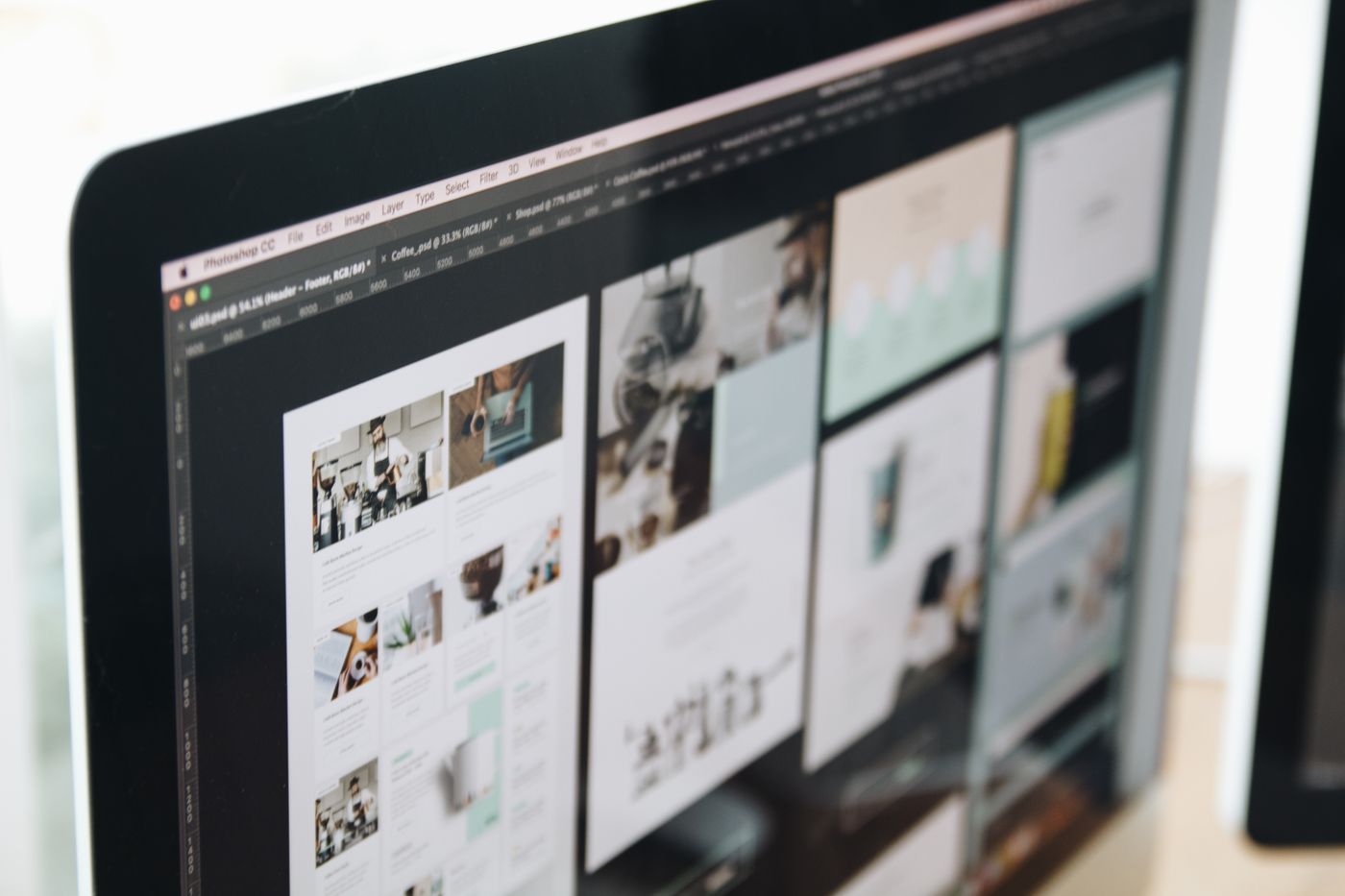 Web design layouts open in an editing tool on a monitor